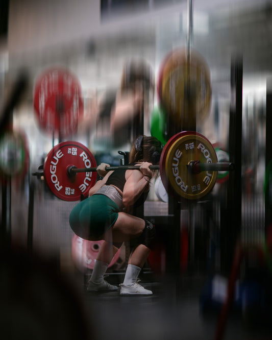 woman doing squats with uppper lifting belt