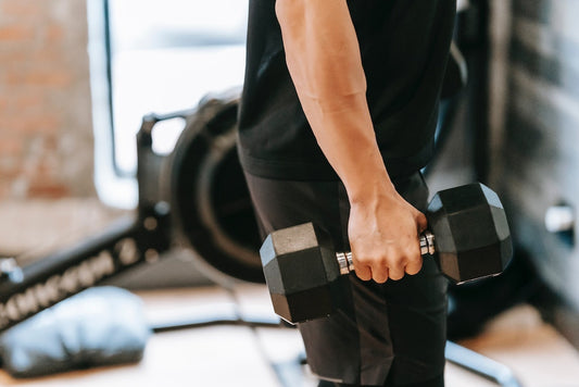 man gripping dumbbell