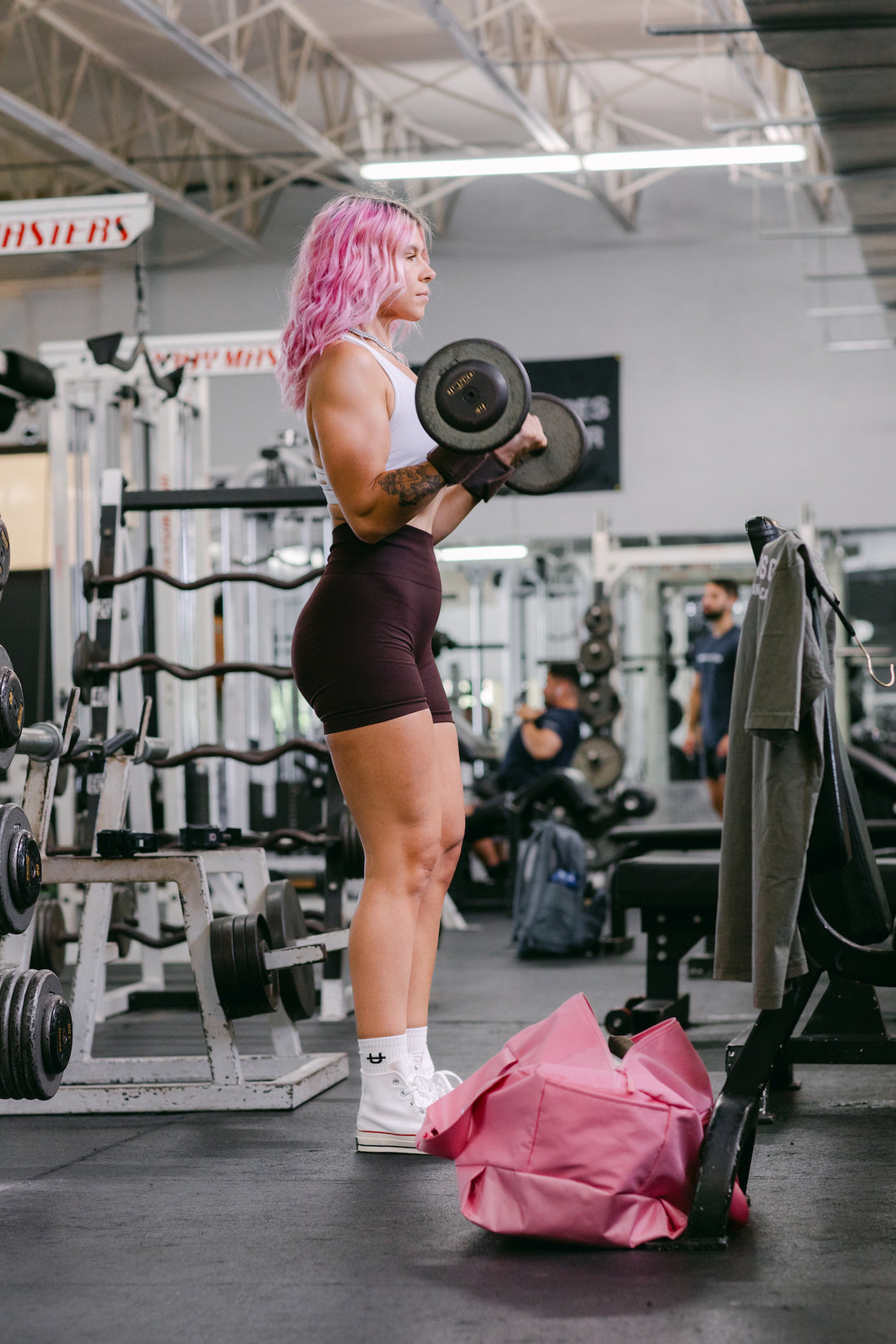 woman doing dumbbell curls for wrist wraps